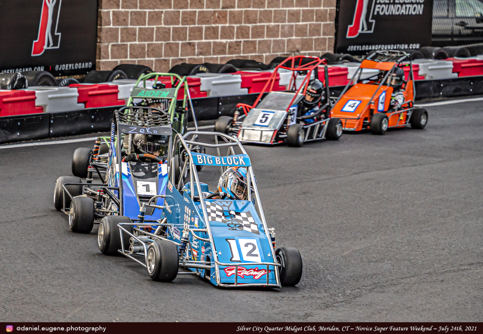 Children in Different Color Karts on a Racing Track